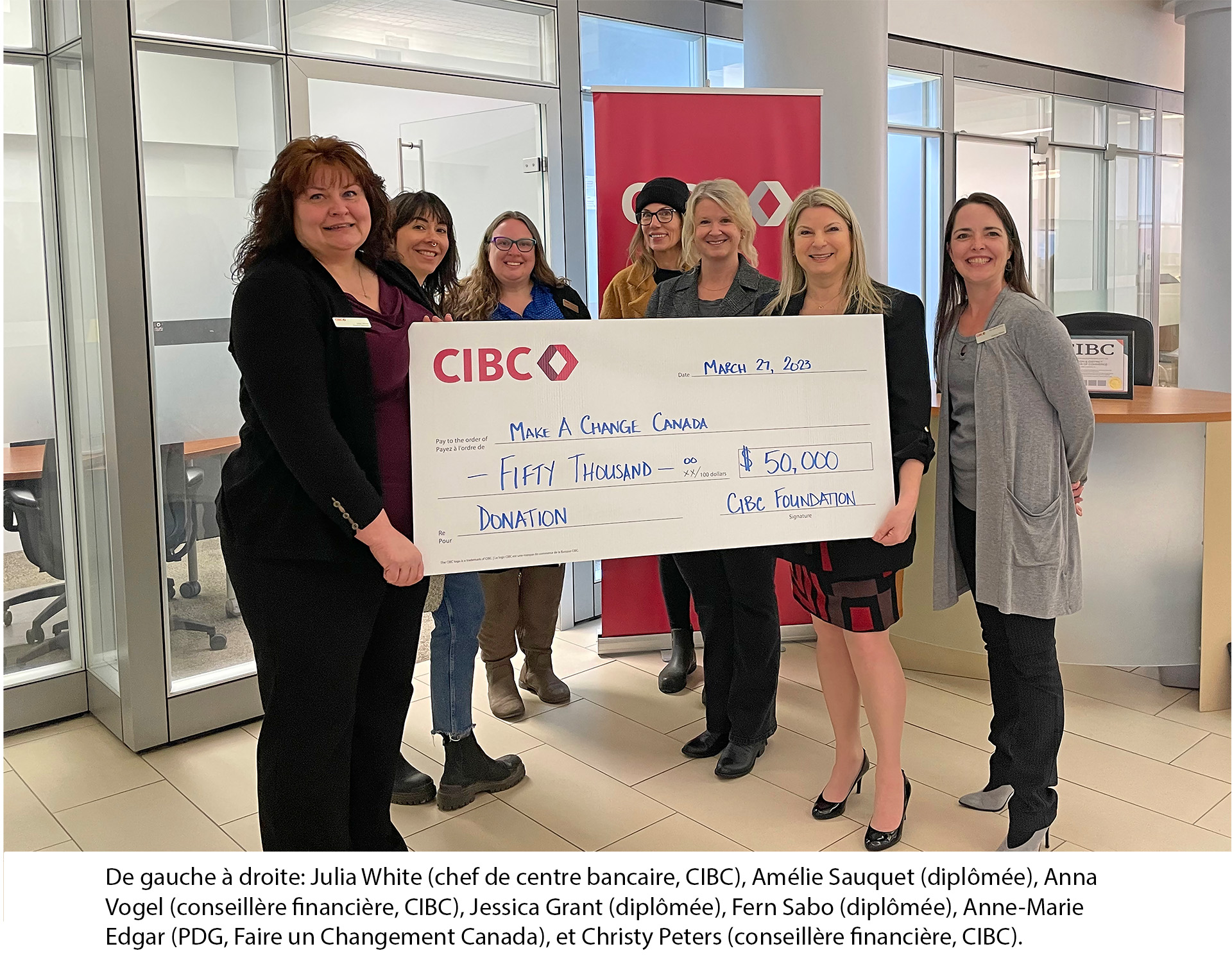 Seven women grouped together holding a jumbo cheque of $50,000 from CIBC Foundation to Make A Change Canada.