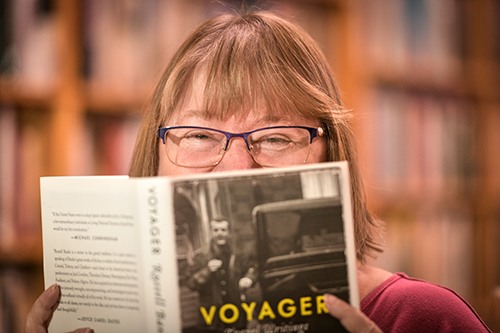 Women hiding behind open book, with eyes only visible.