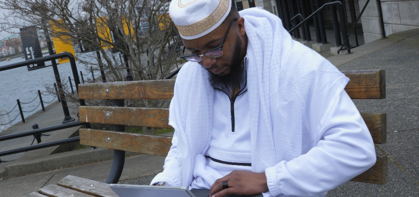 Man sitting on bench with laptop